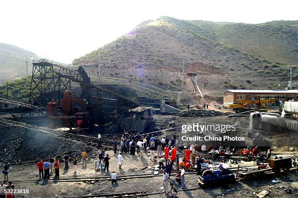 Chinese rescuers gather at the entrance of a pit after a rescue mission at the Shenlong Coal Mine July 11, 2005 in Fukang County of Xinjiang Uygur...