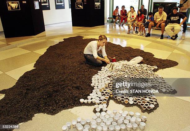 Group of visitor watch as Bosnian-American artist Aida Sehovic pours coffee into cups, 11 July at United Nations headquarters in New York as part of...