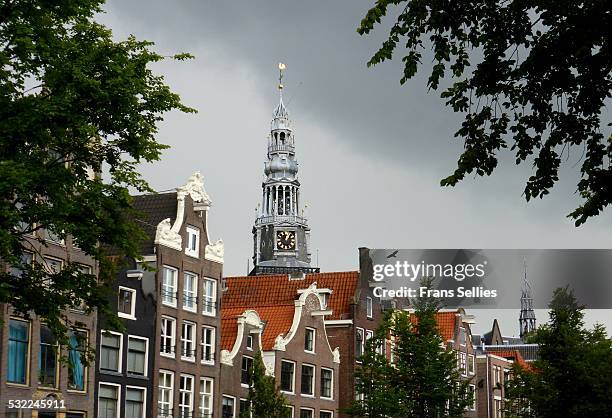 typical dutch canal houses and church tower - gracht amsterdam stockfoto's en -beelden