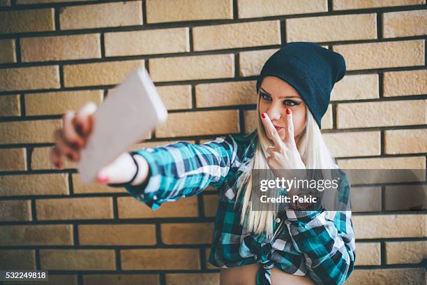 emo girl taking selfie against brick wall - emo stock pictures, royalty-free photos & images