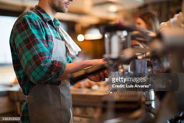 man working in coffee shop - koffiehuis stockfoto's en -beelden