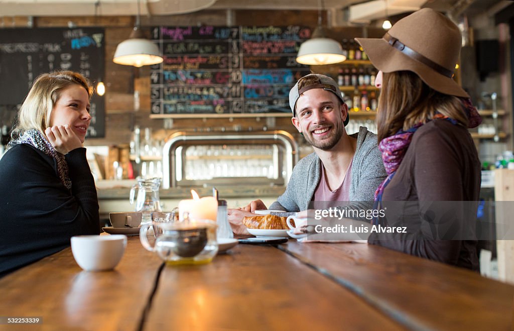 Friends listening to woman at coffee table