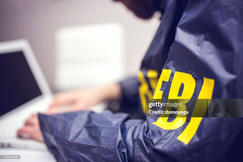 Policeman using laptop in office
