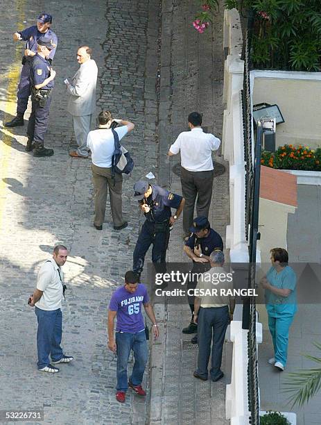 Policemen search near the Italian Cultural Institute after a small bomb exploded early 12 July 2005, outside the Italian cultural center in...