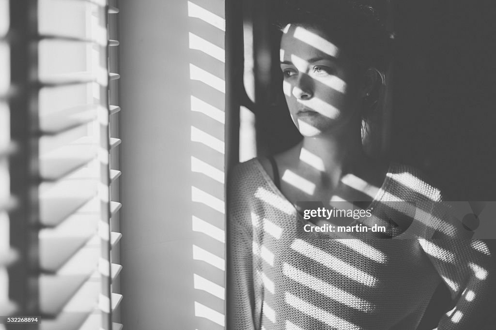 Sad woman looking through the window