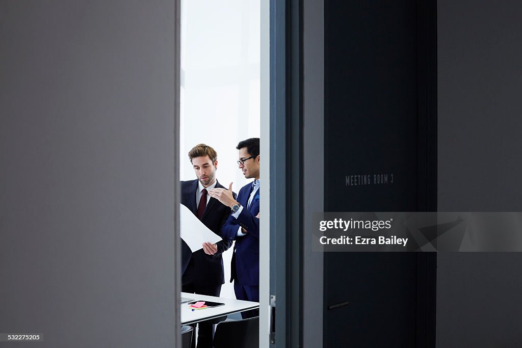 Businessmen discussing plans in smart office.