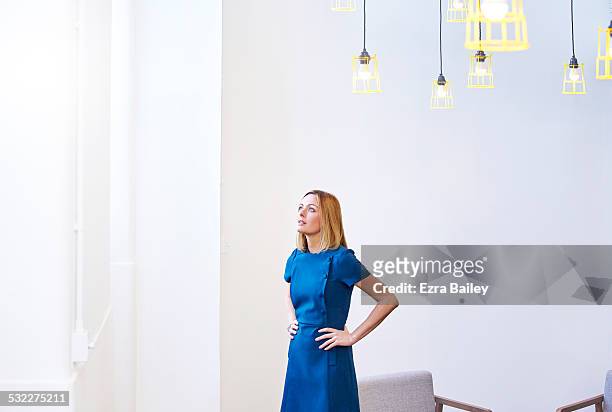 female office worker looking for inspiration. - blue dress imagens e fotografias de stock