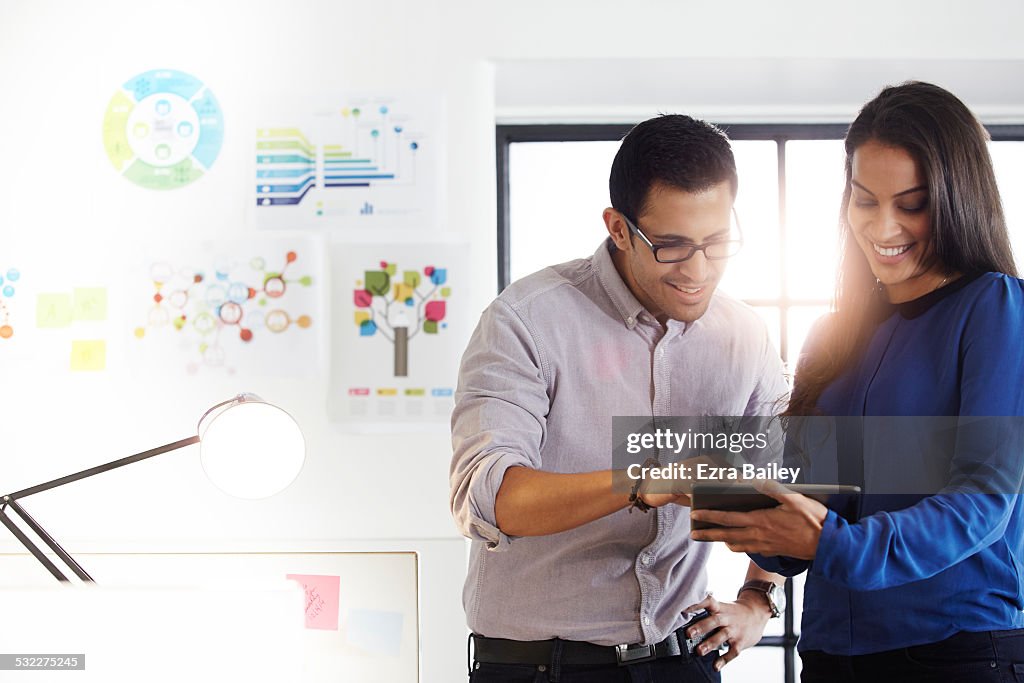 Work colleagues using a tablet to brainstorm.