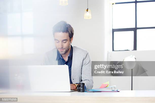 businessman hot-desking in an open plan office. - open laptop on desk stock-fotos und bilder