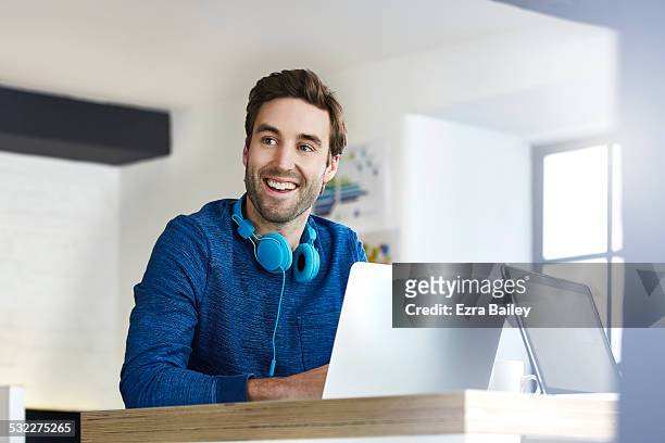 young creative working in an open plan office - homem de azul imagens e fotografias de stock