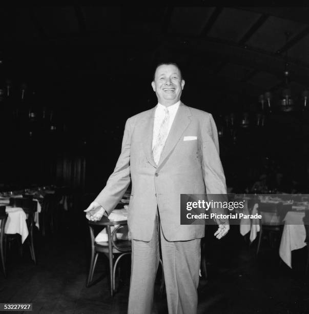 American restaurant owner Toots Shor stands in the dining area of his restaurant, New York, New York, 1950s.