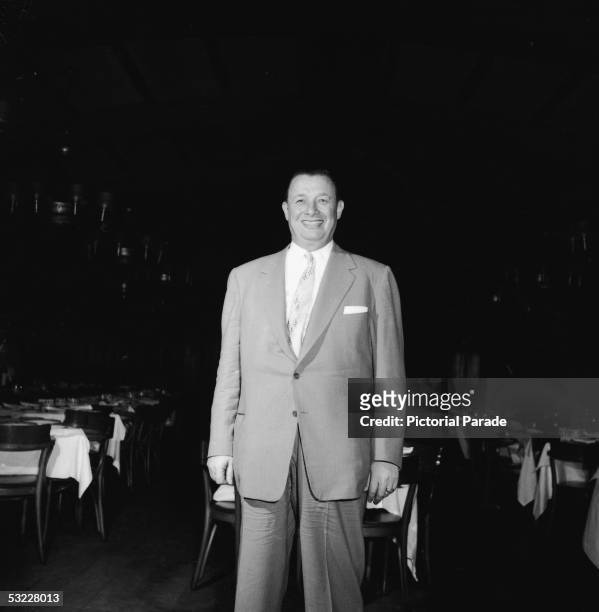 American restaurant owner Toots Shor stands in the dining area of his restaurant, New York, New York, 1950s.