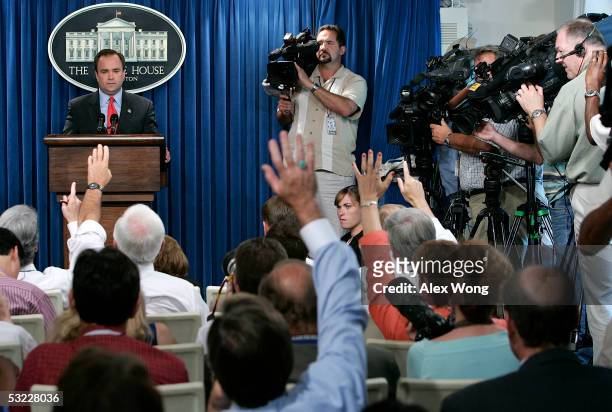 Members of the media raise their hands to ask questions to White House Press Secretary Scott McClellan during the daily news briefing July 12, 2005...