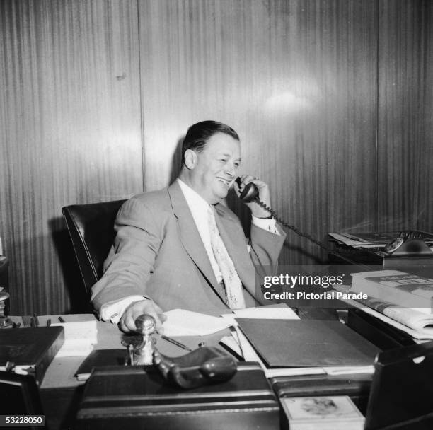 American restaurant owner Toots Shor talks on the phone inside his office at his restaurant, New York, New York, 1950s.