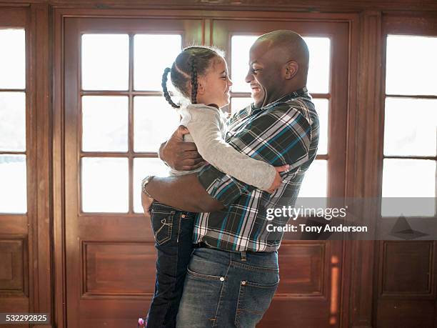 father holding and hugging young daughter - genderblend2015 stock pictures, royalty-free photos & images