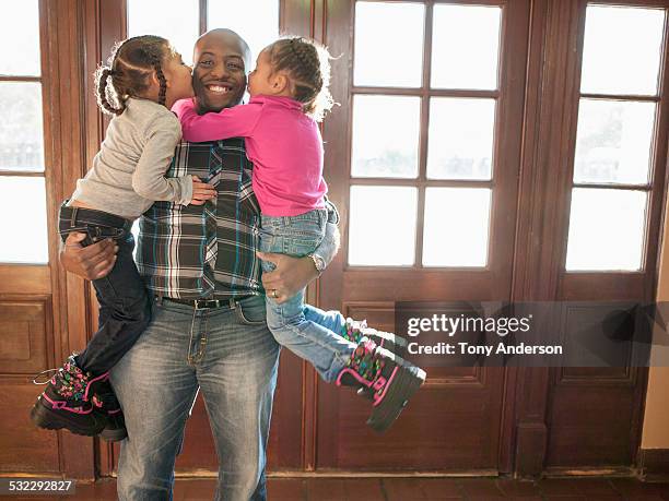 twin daughters hugging and kissing father - genderblend2015 stock pictures, royalty-free photos & images