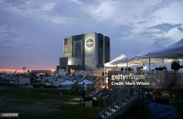 Members of the media stand camped out near the Vehicle Assembly Building as the sun sets at the Kennedy Space Center July 12, 2005 in Cape Canaveral,...