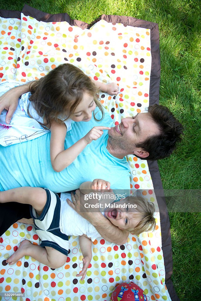 Family lying down on a picnic blanket