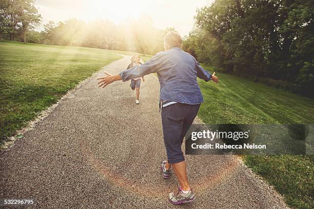 granddaughter running to grandma for a hug - nieto fotografías e imágenes de stock