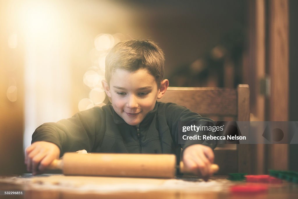 Boy rolling out Christmas cookie dough
