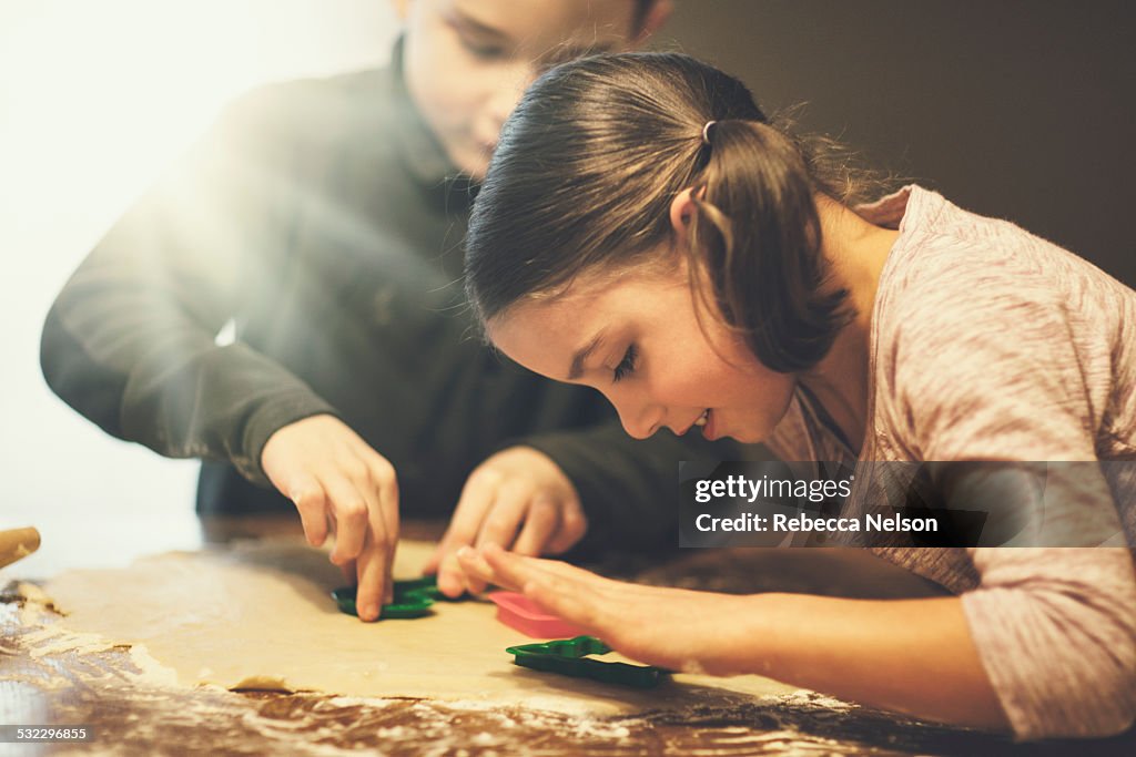 Boy and girl cutting out Christmas cookies