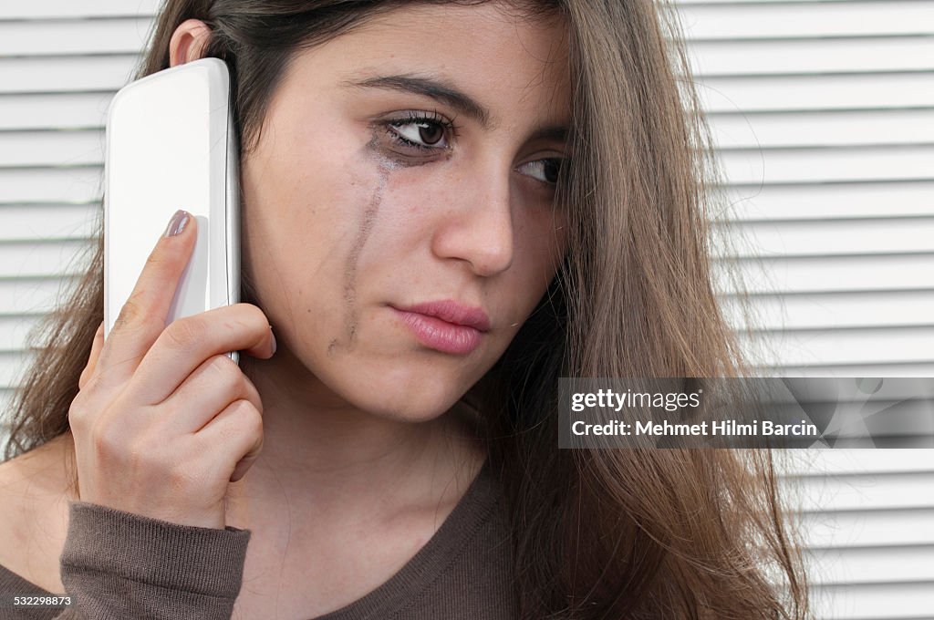 Teenage girl talking with mobile phone in depression