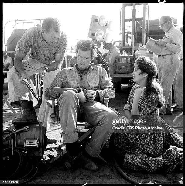 American actor, and later director, Clint Eastwood reads a script while director James P. Yarbrough talks to him and co-star Karen Sharpe who sits...