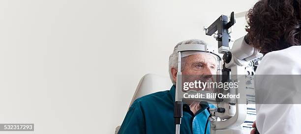 optometrist with patient - hoornvlies stockfoto's en -beelden