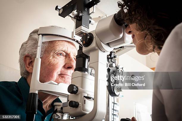 optometrist with patient - macular degeneration stock pictures, royalty-free photos & images