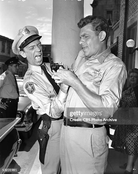 American actors Don Knotts and Andy Griffith struggle for a gun during an episode of the CBS rural sitcom 'The Andy Griffith Show,' California, 1960....