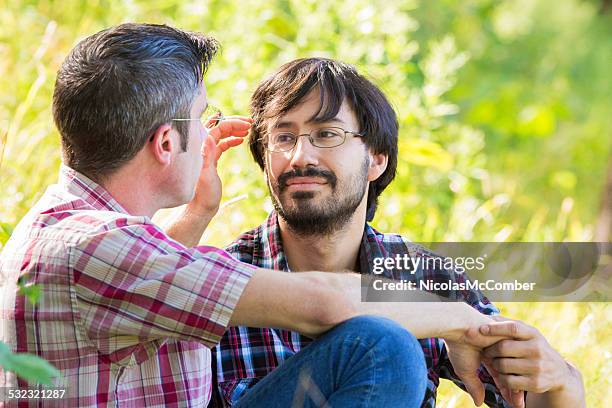 junger bärtiger gay hispanic mann genießen sie die romantik mit boyfriend-park - hand in den haaren stock-fotos und bilder