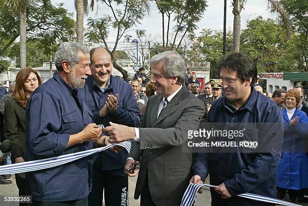 El presidente de Uruguay Tabare Vazquez , entrega al dirigente del Sindicato de trabajadores de la Industria del Caucho, Luis Romero , un trozo de...