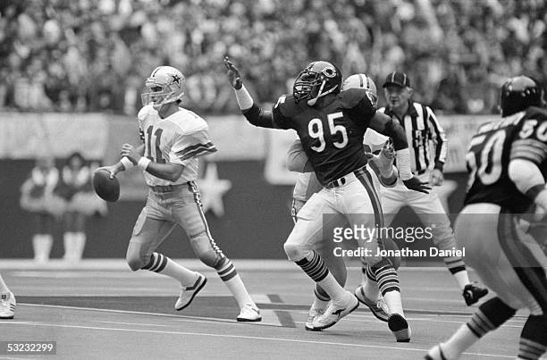 Danny White of the Dallas Cowboys scrambles under pressure from Richard Dent of the Chicago Bears during the game at Texas Stadium on November 17,...