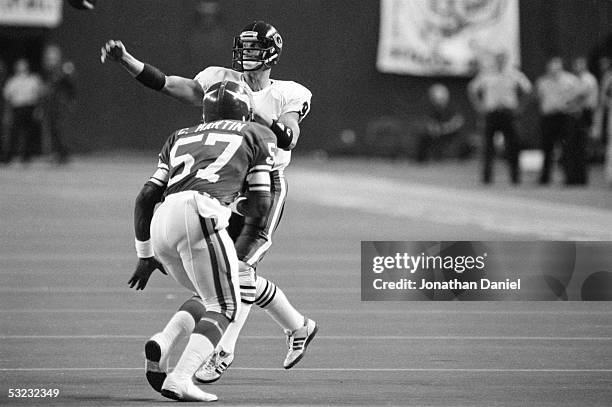 Jim McMahon of the Chicago Bears throws a pass under pressure from Chris Martin of the Minnesota Vikings during the game at the Metrodome on...
