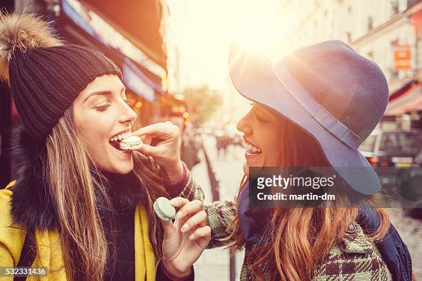 attraente donna mangiare parigino amaretti (biscotti) - cultura francese foto e immagini stock