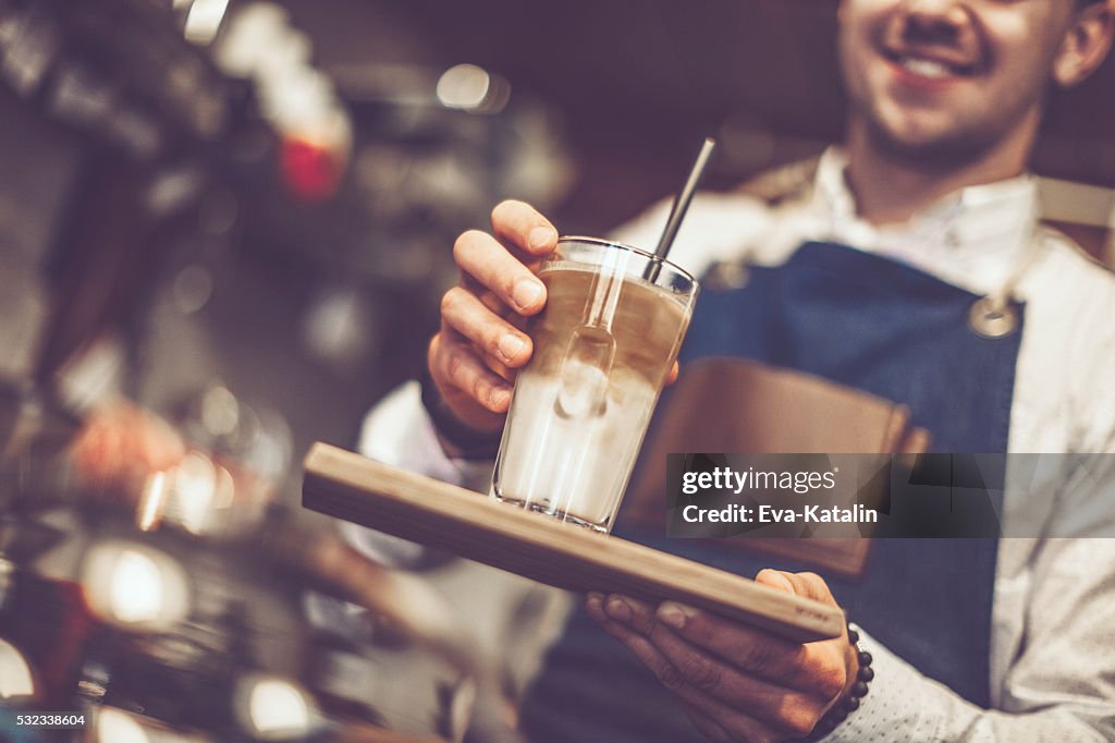 Young barista is offering a coffee speciality