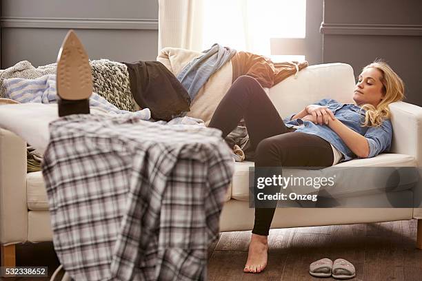 young woman taking a break from housework - messy living room stock pictures, royalty-free photos & images