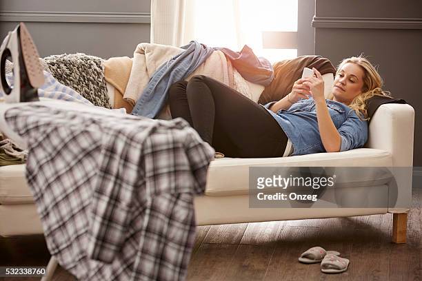 jovem mulher um fazer uma pausa do trabalho doméstico - couch potato imagens e fotografias de stock