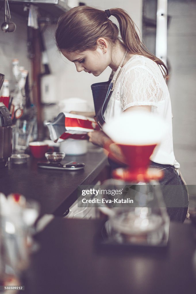 Young barista is making a coffee