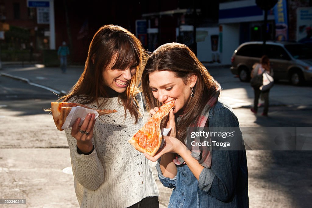 Friends grabbing a slice of pizza on the go