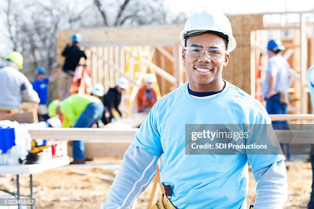 confident volunteer construction foreman at work site - hispanic construction worker stock pictures, royalty-free photos & images