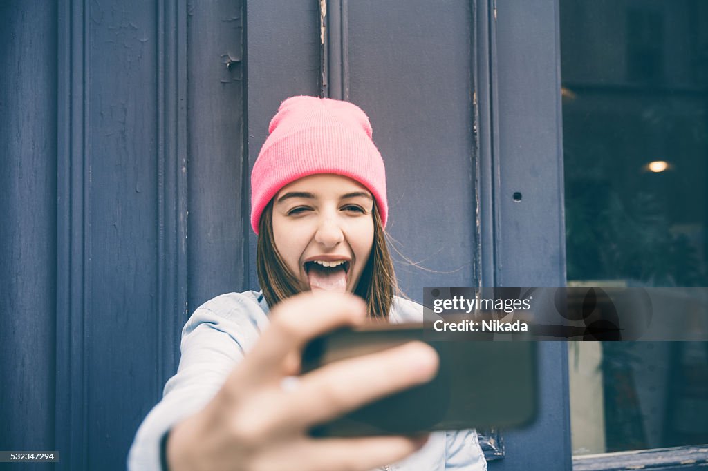 Chica adolescente que autofoto y hacer muecas