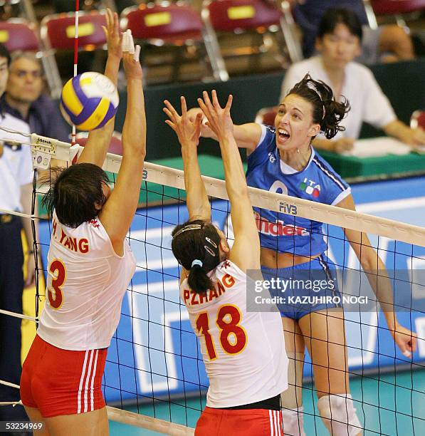 Italian attacker Nadia Centoni spikes the ball over Chinese defenders, Yang Hao , Zhang Ping during a third set of the World Grand Prix women's...