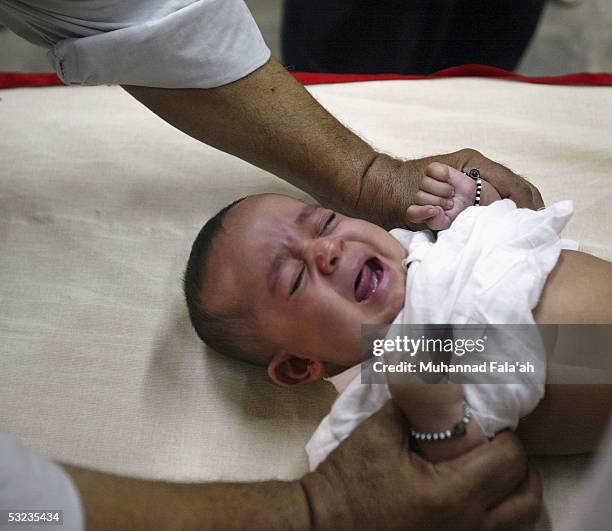 An Iraqi male child cries as he is circumcised July 14, 2005 in Baghdad, Iraq. Circumcision is a religious practice among Muslims and is seen as an...