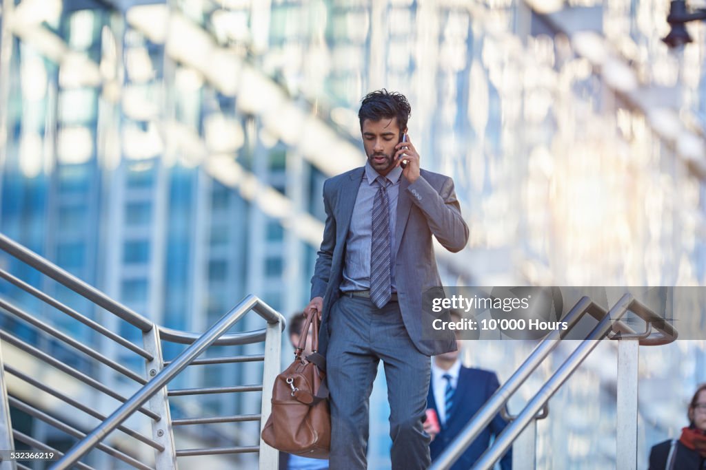 Businessman walking in the city, talking on phone