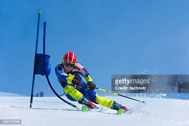junger skifahrer üben giant slalom - slalom skiing stock-fotos und bilder