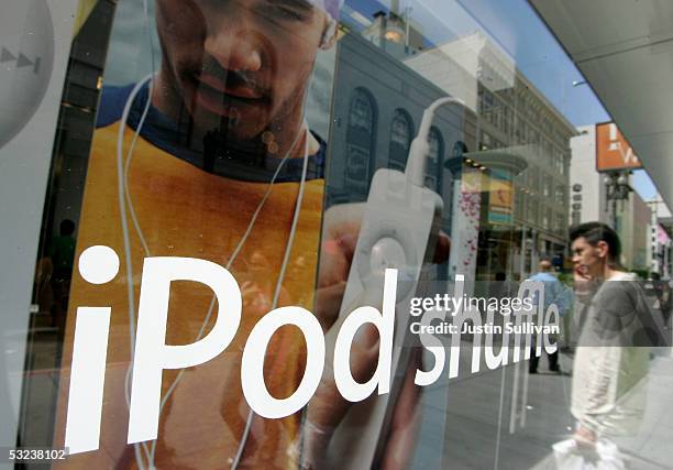 Man, reflected in plate glass, looks at a window display for the iPod Shuffle at the Apple Store July 14, 2005 in San Francisco, California. Shares...