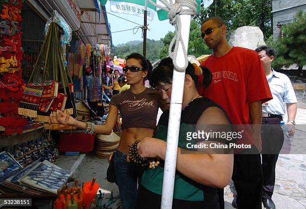 Basketball player Tony Parker of the San Antonio Spurs and his girl friend buy souvenirs as they visit the Great Wall on July 14, 2005 in Beijing,...