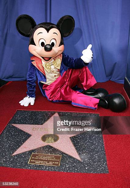 Mickey Mouse poses in front of the Disneyland star of Excellence presented by the Hollywood Historic Trust to mark Disneylands 50th anniversary...