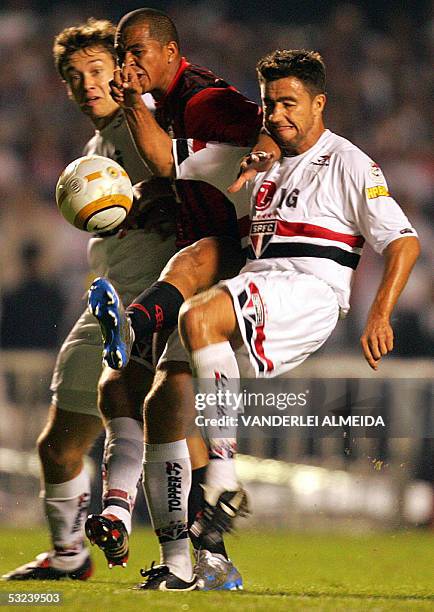 Sao Paulo's players Alex Costa and Diego Lugano vie for the ball with Atletico Paranaense's Aloisio Silva, 14 July 2005, during their Libertadores...
